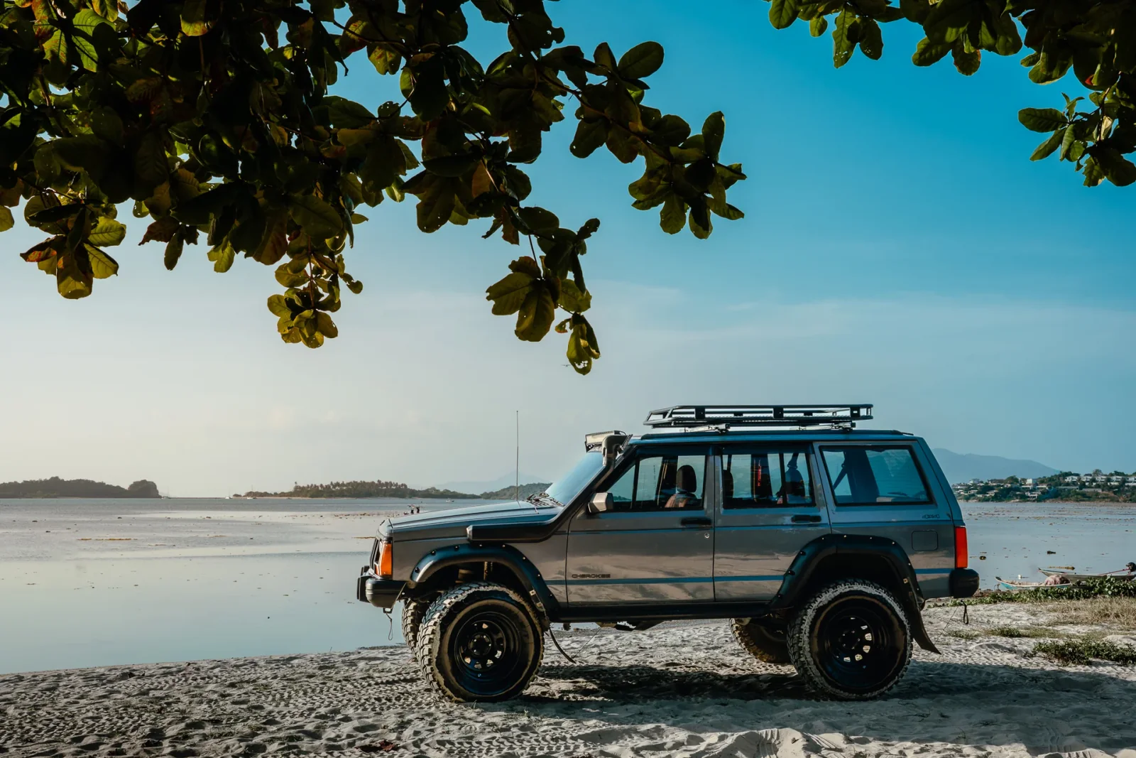 Jeep Grey Ghost garée au bord de la mer à Koh Samui au coucher du soleil