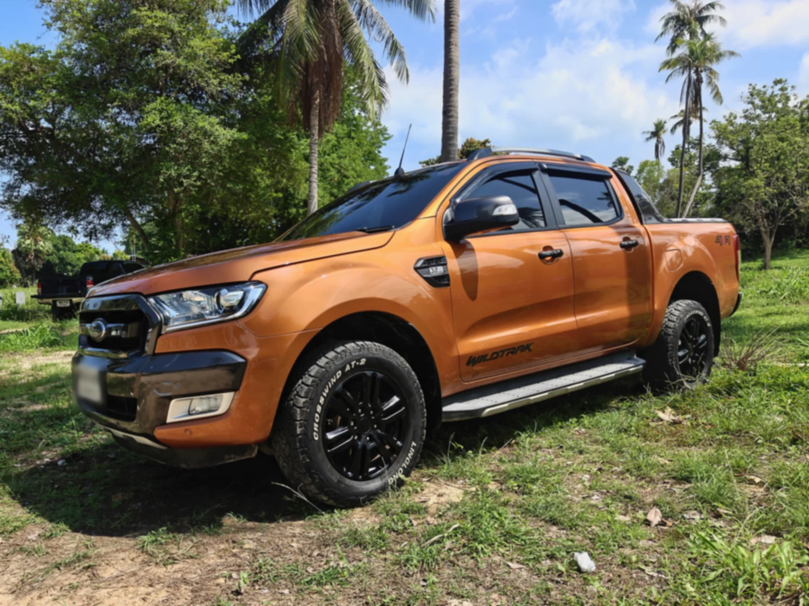 Оранжевый Ford Ranger Wildtrak 3.2 2015 года с двойной кабиной, вид сбоку у моря на Самуи