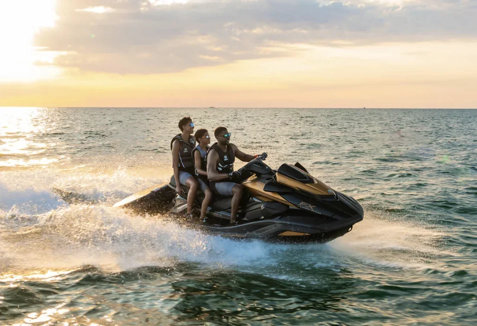 Three riders wearing life jackets on a Yamaha FX SVHO at sunset